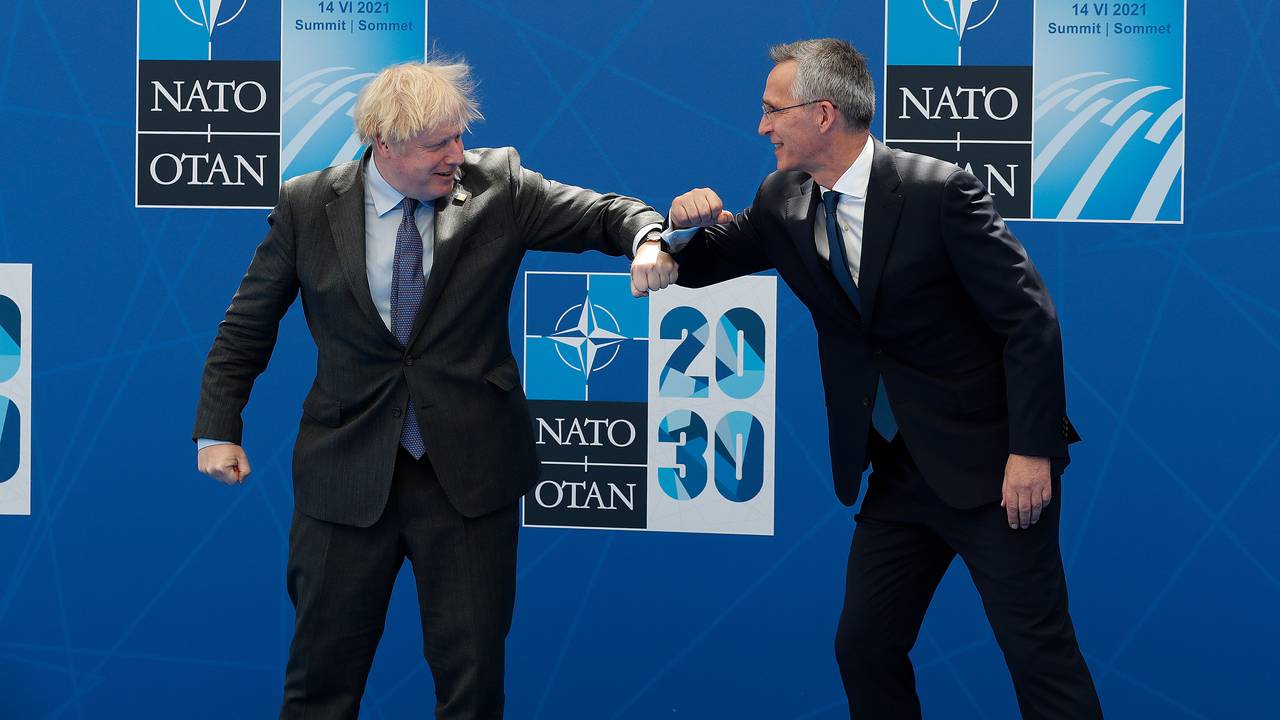 Storbritannias statsminister Boris Johnson tar en koronahilsen på Natos generalsekretær Jens Stoltenberg før toppmøtet.