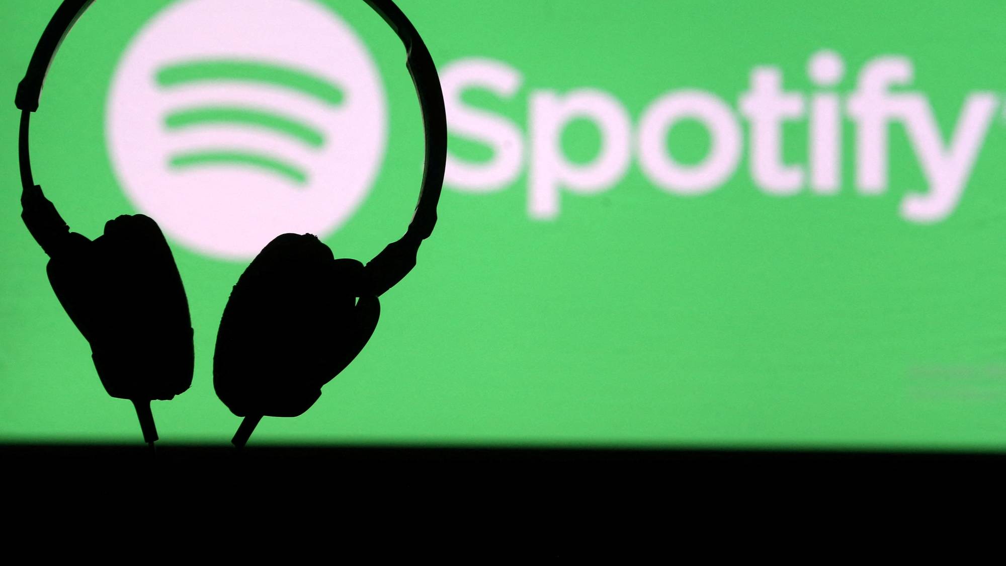 Spotify-logoen bak eit sett med hodetelefonar