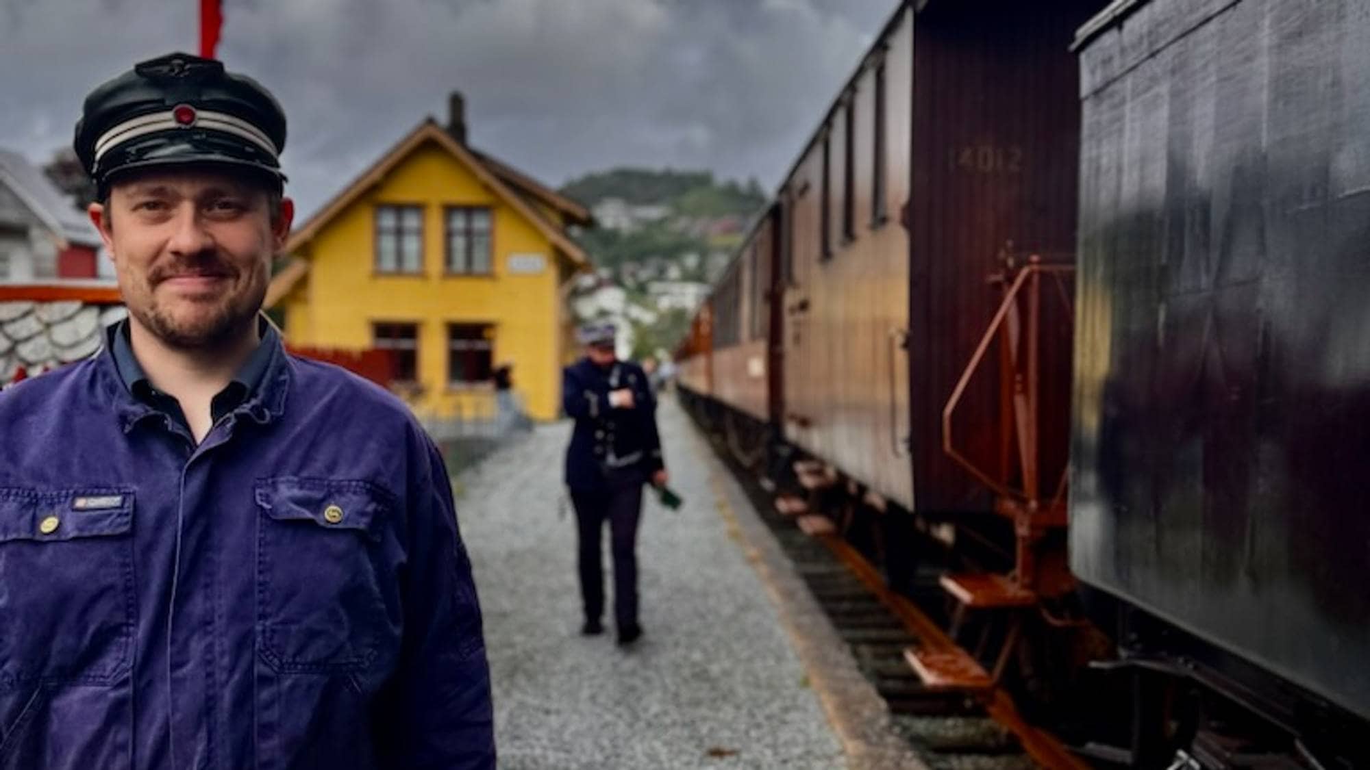 mann med uniform ved eit tog