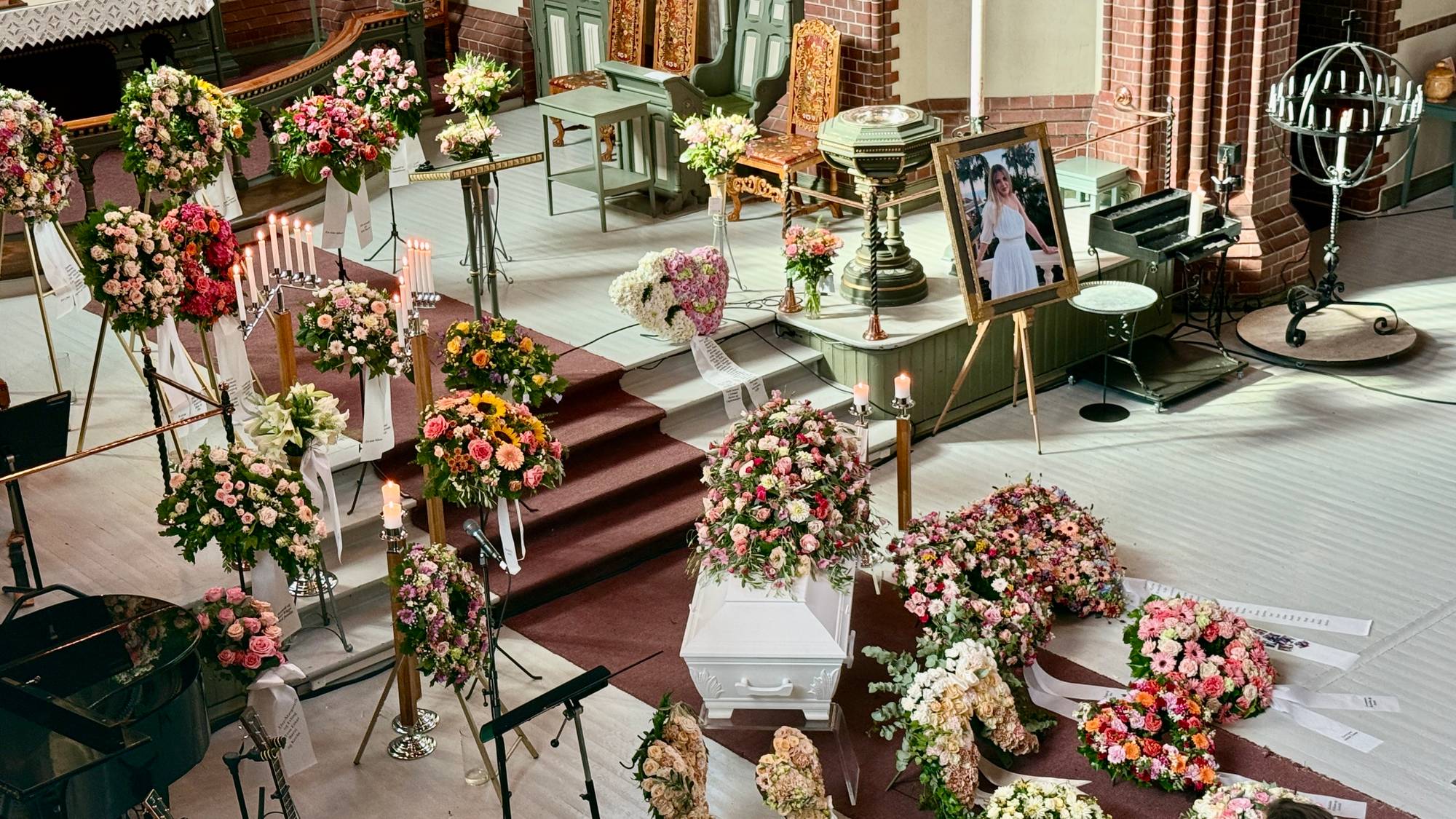 Kirkerom med kiste og fargerike blomster