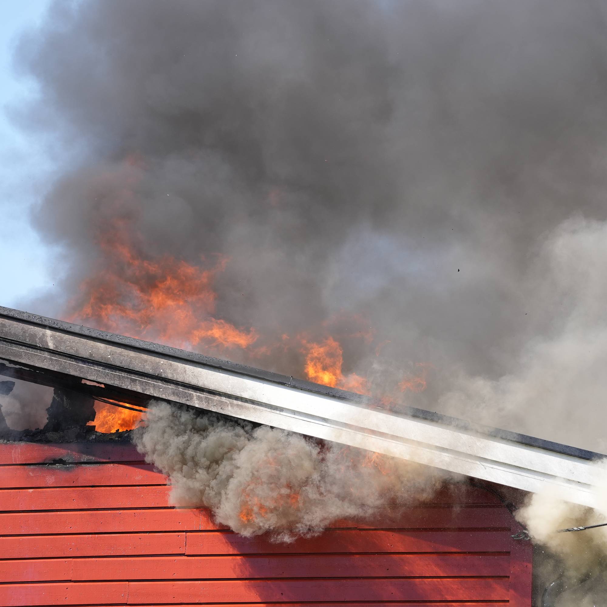 Flammer står ut av et rekkehus.