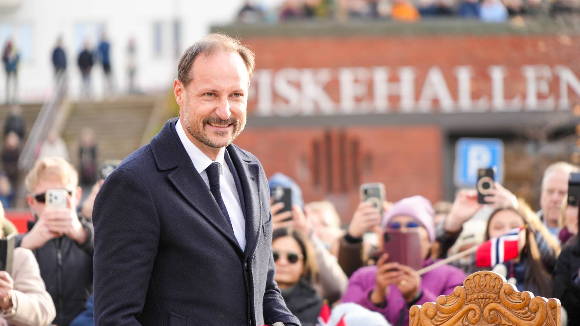 Kong Haakon vinker til folk i et folkehav av unge og gamle
