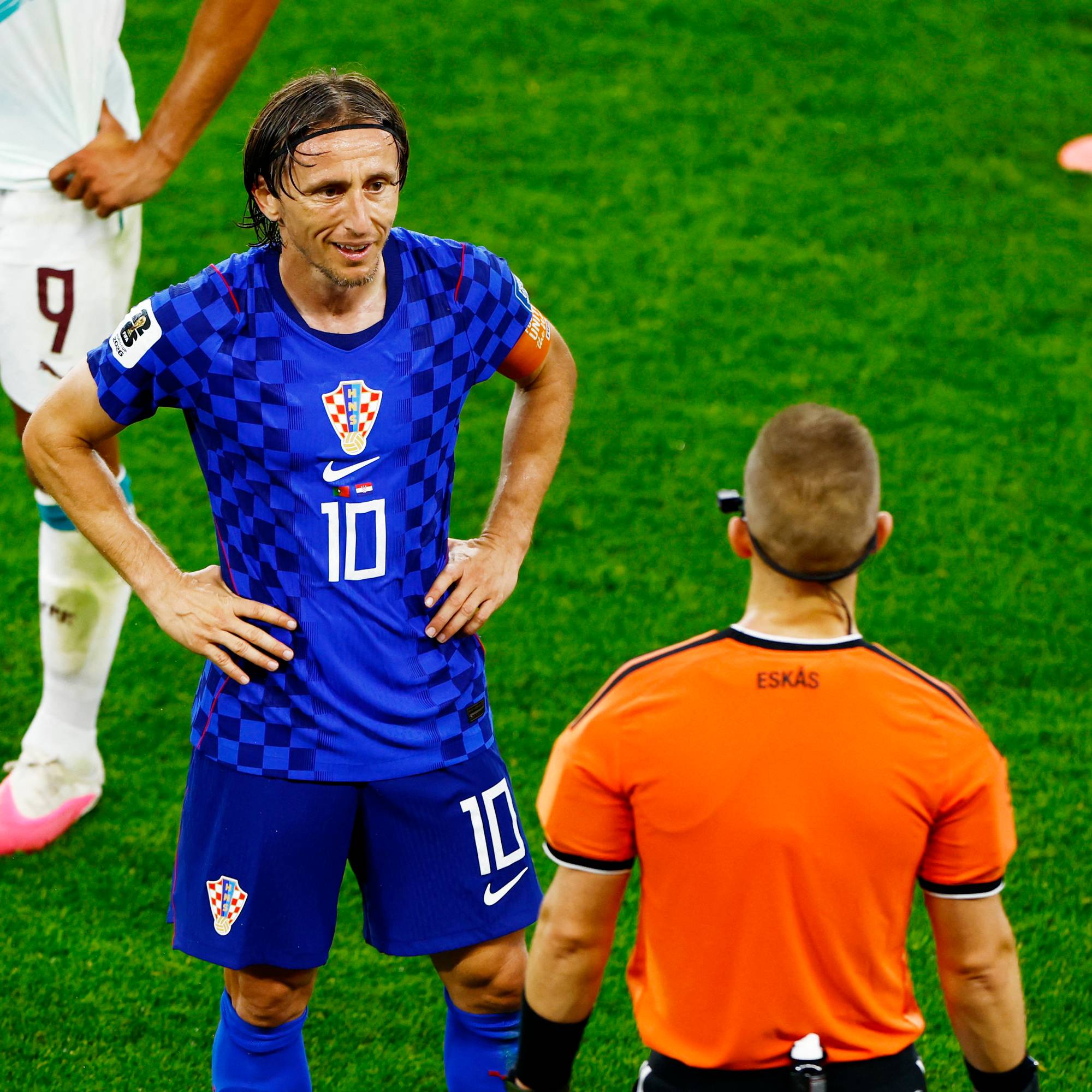 Luka Modric i Kroatias landslagsdrakt snakker med dommer Espen Eskås på en fotballbane. (Bildebeskrivelsen er laget av en KI-tjeneste)