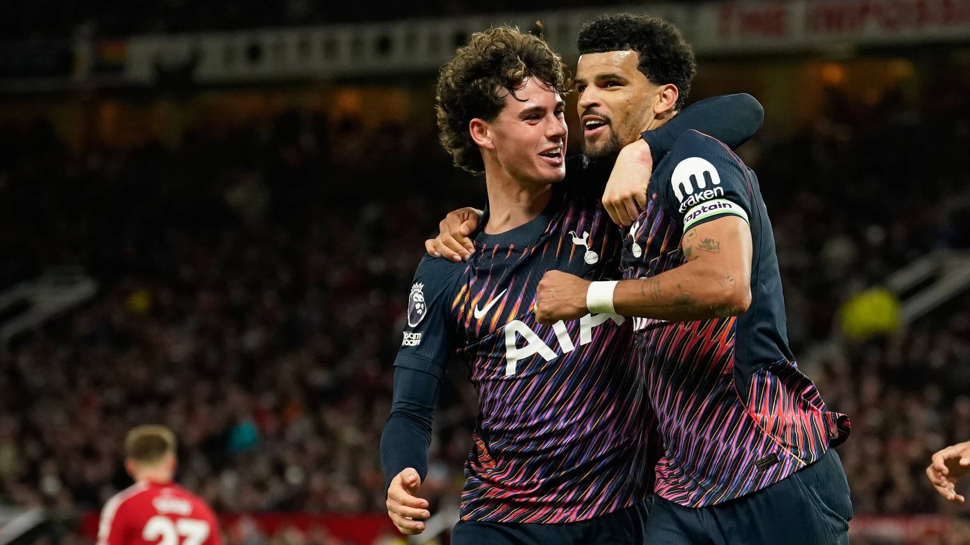To fotballspillere i Tottenham-drakter feirer sammen på banen foran publikum. (Bildebeskrivelsen er laget av en KI-tjeneste)