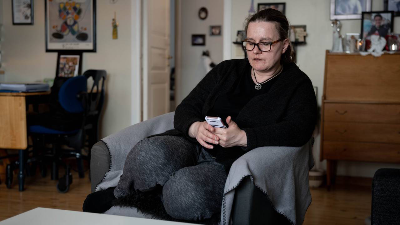 Andrines mor Heidi sitter i en stol og ser ned på Andrines telefon.