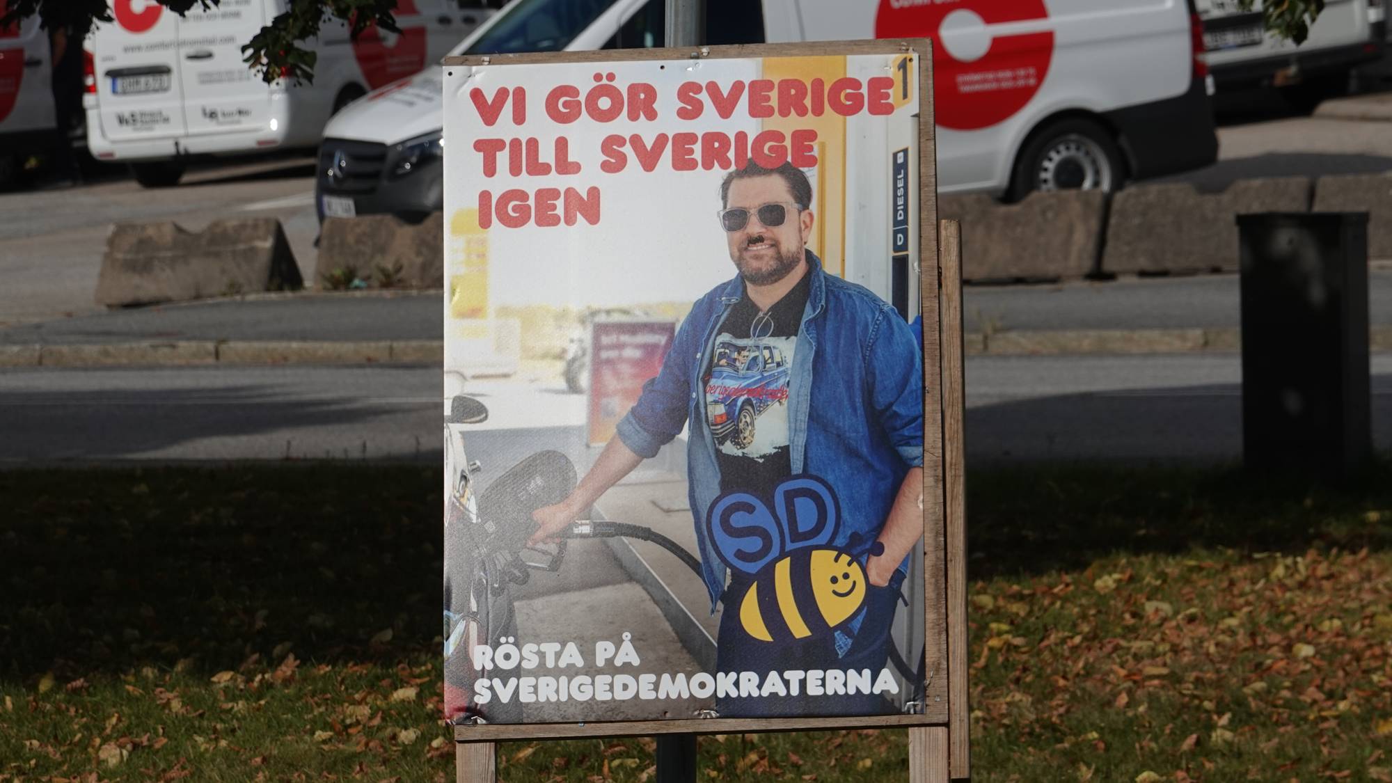Valgplakat for Sverigedemokraterna montert på et stativ utendørs. (Bildebeskrivelsen er laget av en KI-tjeneste)