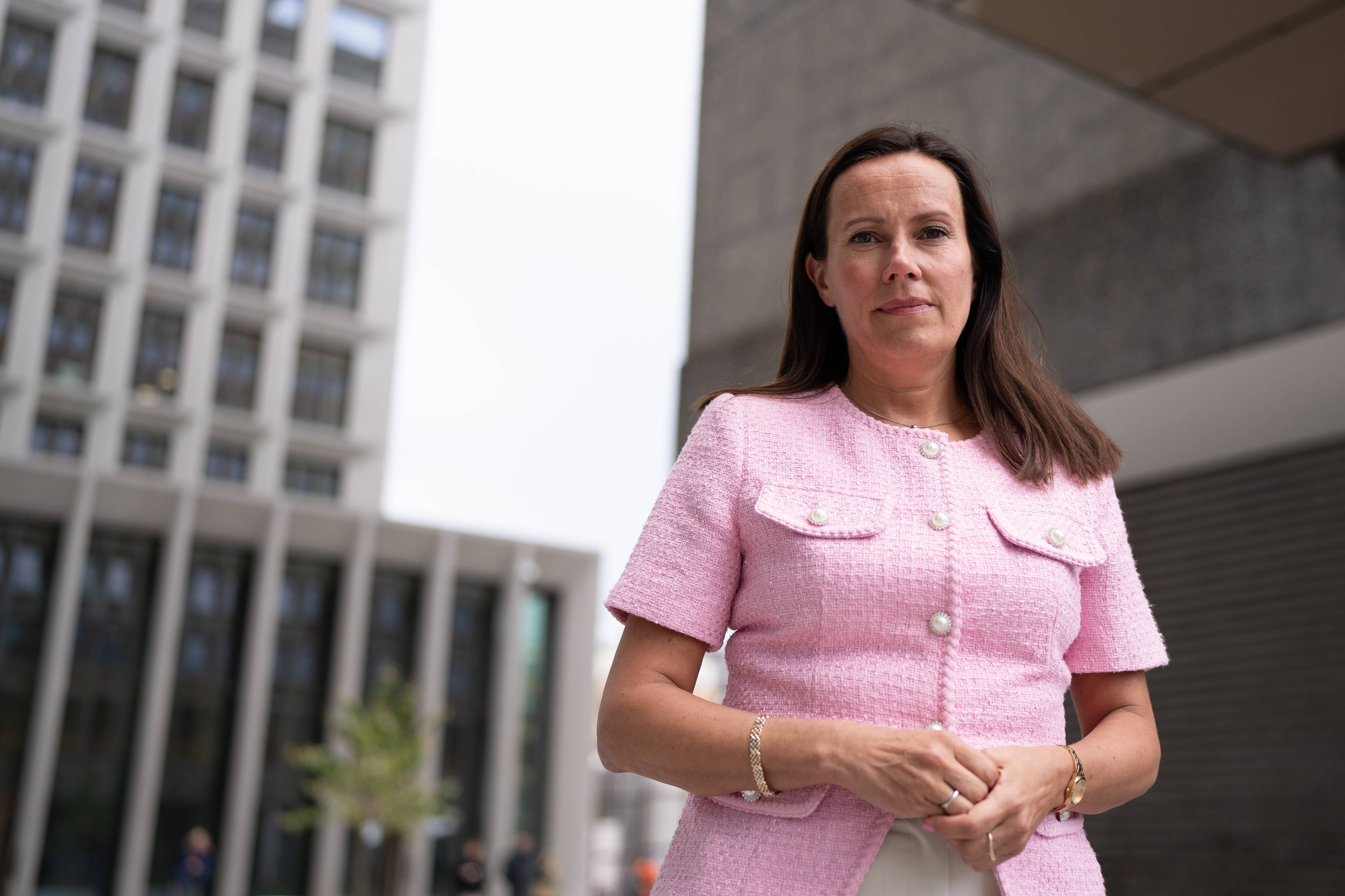 Fiskeri- og havminister Marianne Sivertsen Næss (Ap) ser ned på kameralinsen. Hun har brunt, rett hår og en rosa topp på seg. Bak henne er deler av regjeringskvartalet i Oslo.