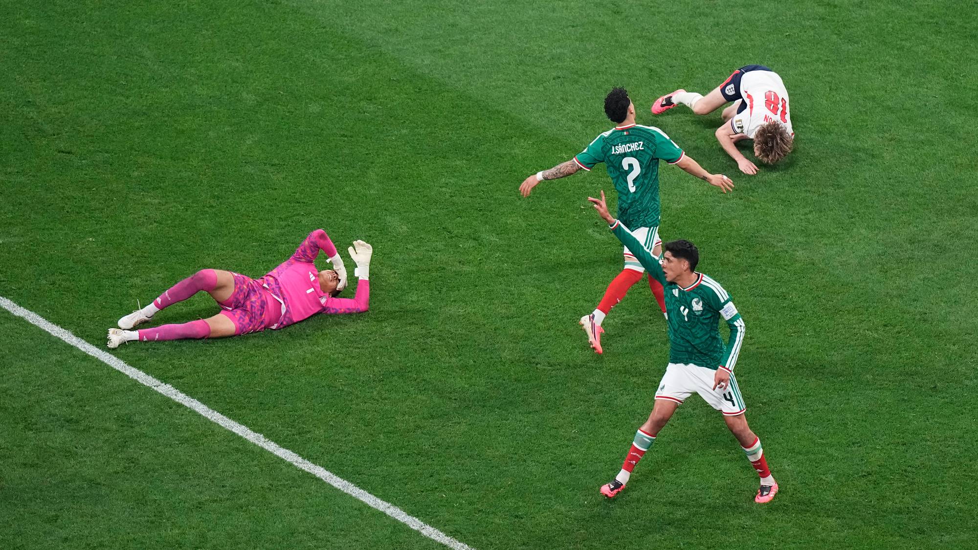 Fotballspillere fra Mexico og England på gresset etter en situasjon i en fotballkamp. (Bildebeskrivelsen er laget av en KI-tjeneste)