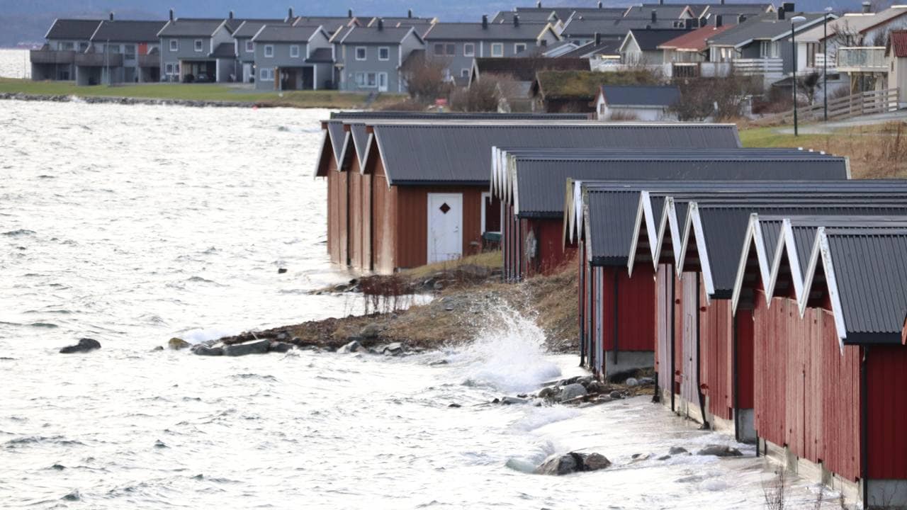 Vannet slår mot båthusene i Brekstad i Trøndelag.